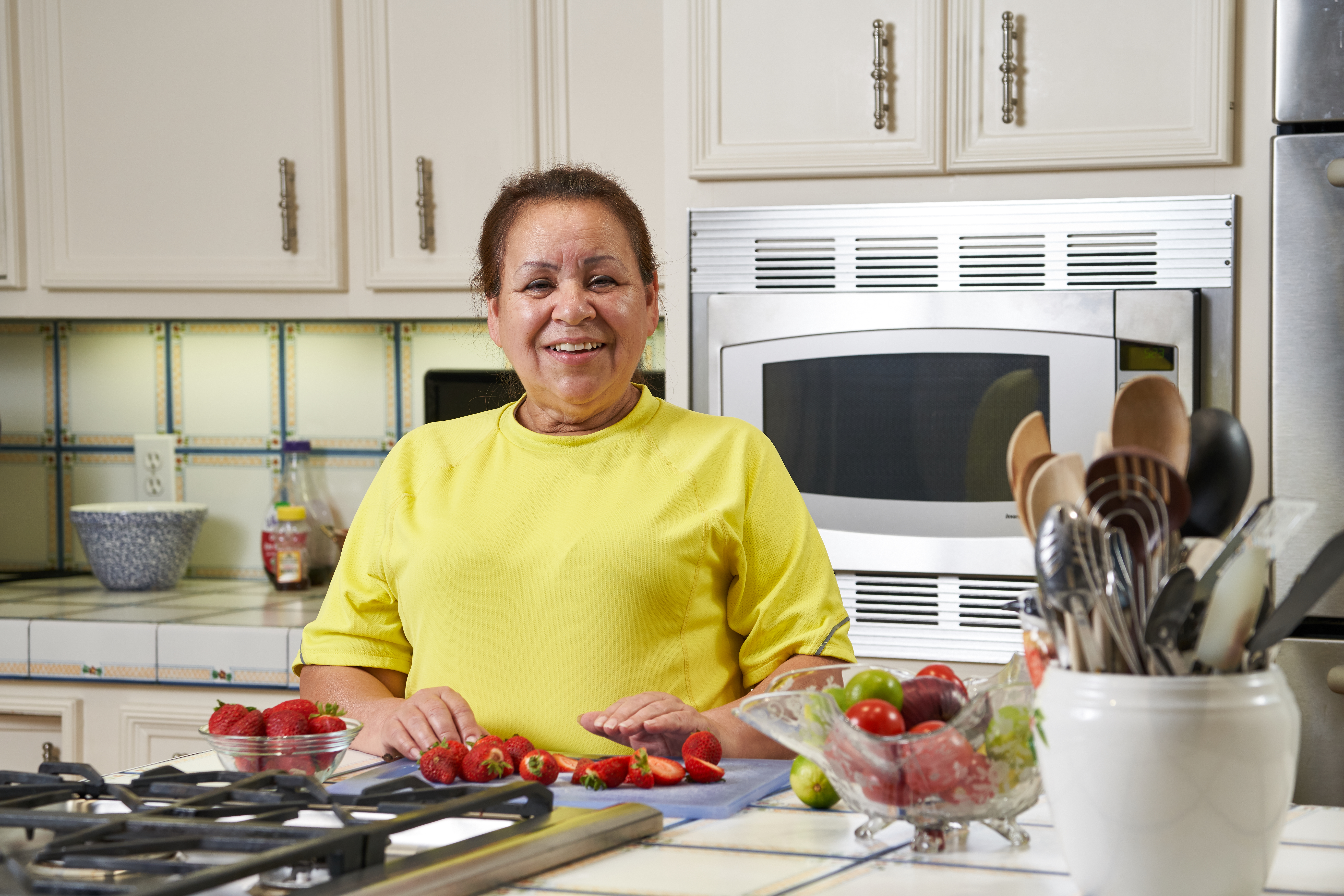 Woman cutting strawberries and smiling